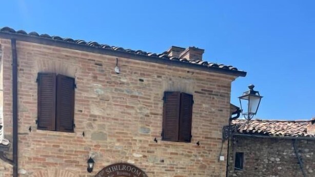 A traditional brick building with a sign indicating 'Sibillero Room.' - Sibilroom - Rooms & Wellness (Amandola)