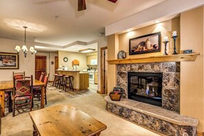 Una sala de estar acogedora con chimenea, mesa de comedor de madera y sillas.