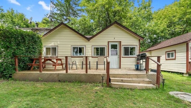 A two-story house with a front porch, a small deck, and a garage. - Relaxing Countryside Stay (Bailieboro)