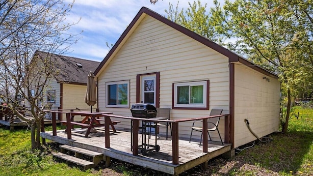Een gelijkvloers huis met een terras, een barbecue en een raam met uitzicht.
