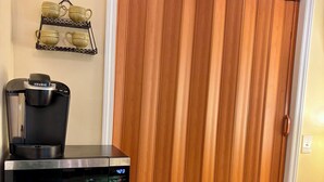 Una cuina americana equipada amb cafetera, rellotge digital i nevera.