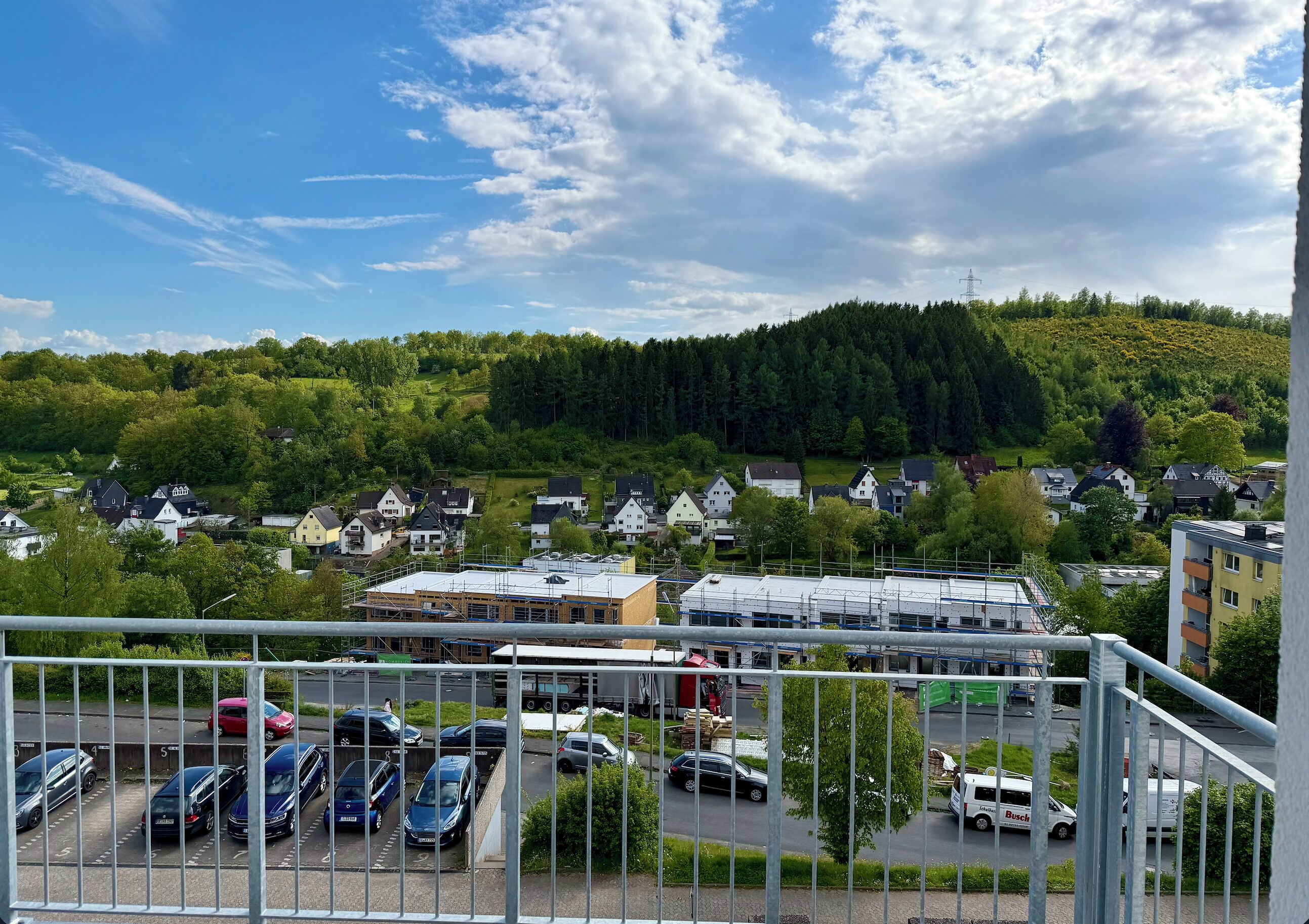 A residential area with houses, a parking lot, and a building under construction.