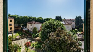 Quartiere residenziale con edifici, cielo sereno e un albero in primo piano.