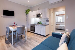 A compact living space with a kitchenette, dining area, and a sofa. - Civette A, Studio Apt with Shared Garden View (Greve in Chianti)
