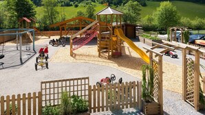 Une aire de jeux avec un toboggan, des balançoires et une structure d’escalade.