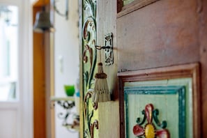A wooden door with a brass handle and a decorative brass plate.