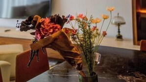 Ein Essbereich mit Pendelleuchten, einer Blumenvase und einem Holztisch.