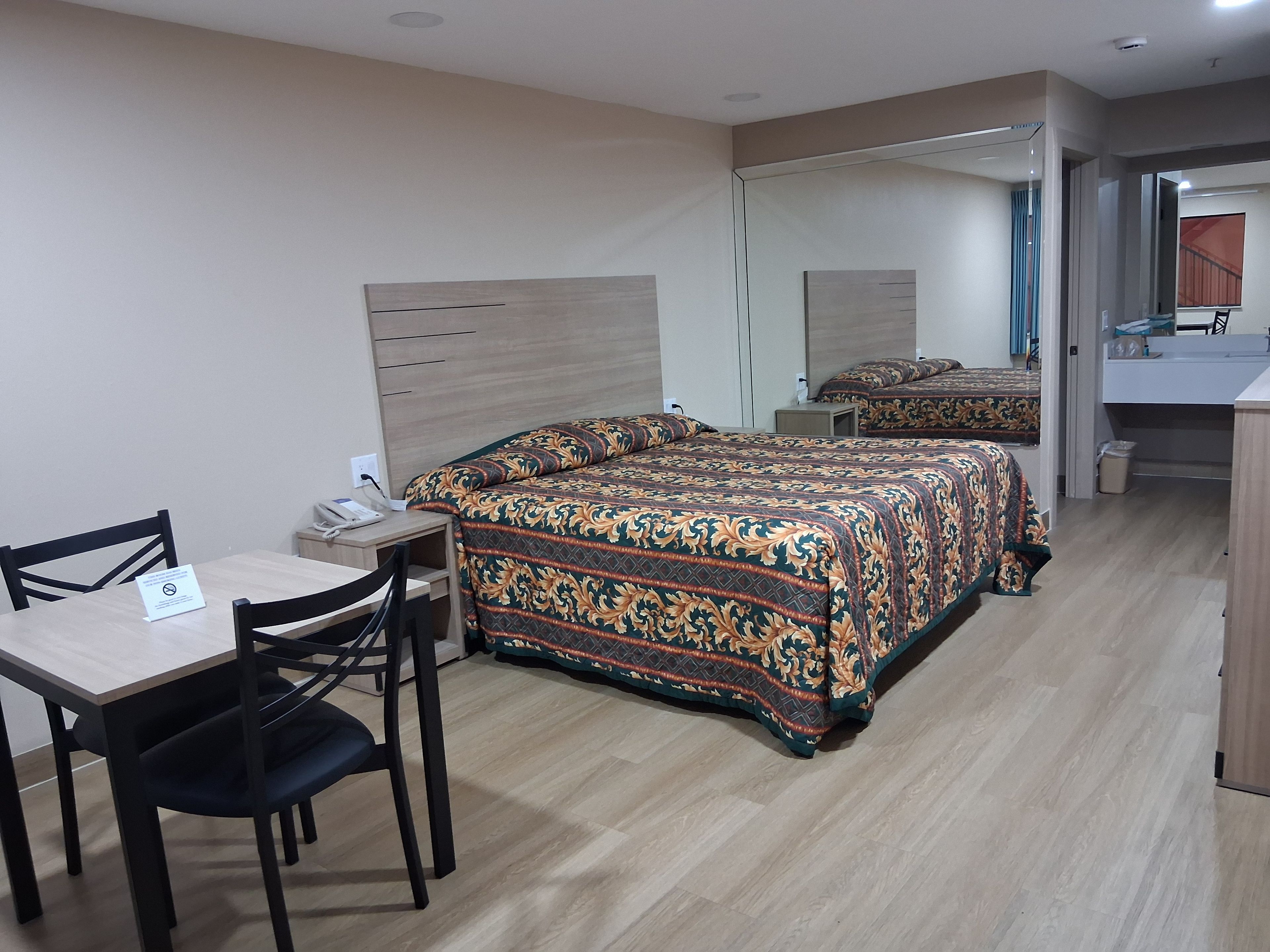 Une chambre d’hôtel avec un lit, un bureau et une chaise.