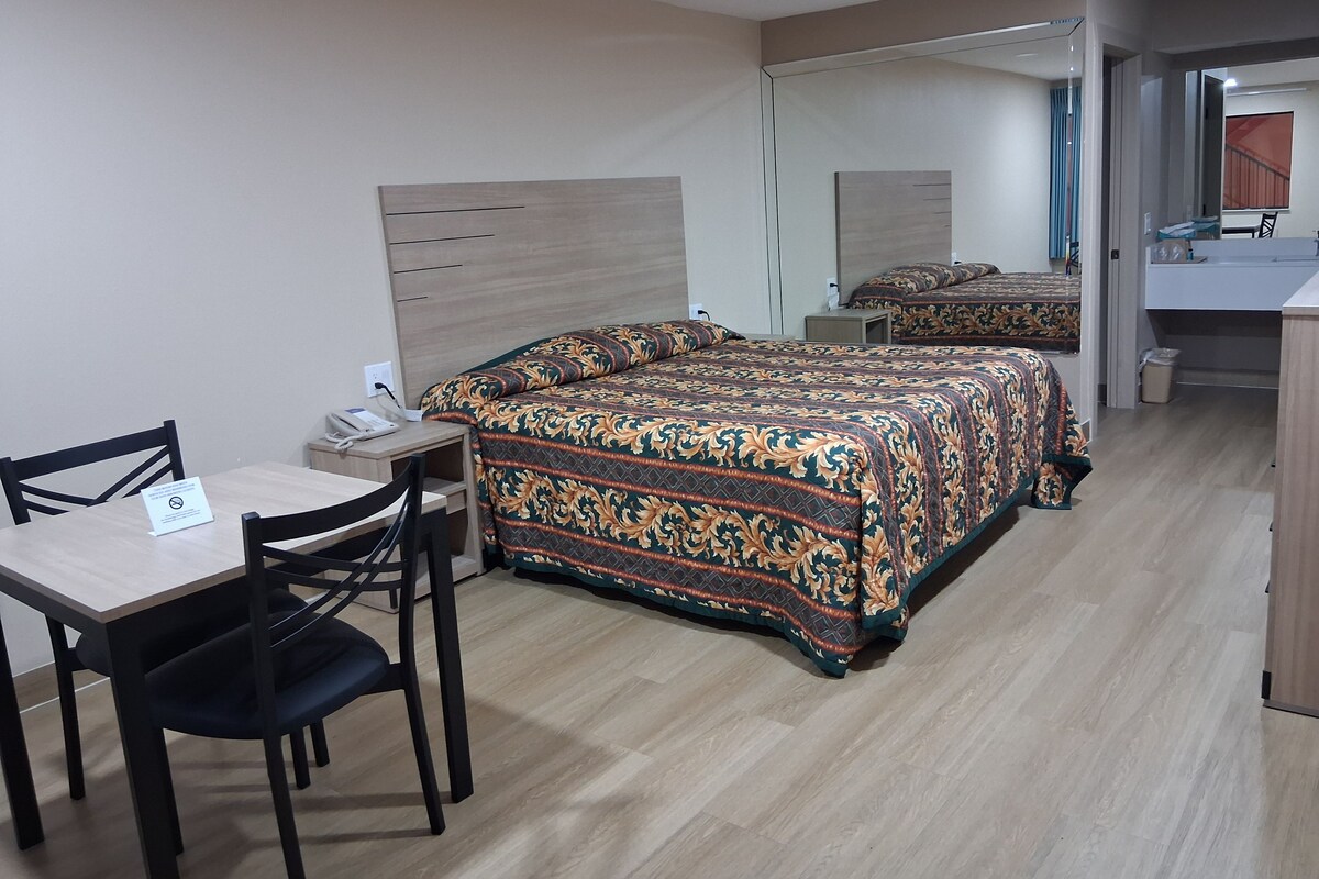 Una camera d'albergo con un letto, una scrivania e una sedia.