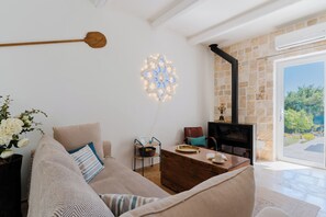 Ein modernes Wohnzimmer mit einer Couch, einem Couchtisch, einem Kamin und einer dekorativen Wandleuchte.