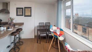 Eine Küche mit Essbereich, Barhocker, einem farbenfrohen Stuhl und einem Fenster mit Blick.