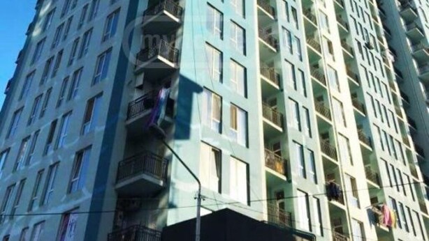 A high-rise residential building with multiple balconies, large windows, and a modern architectural design.
