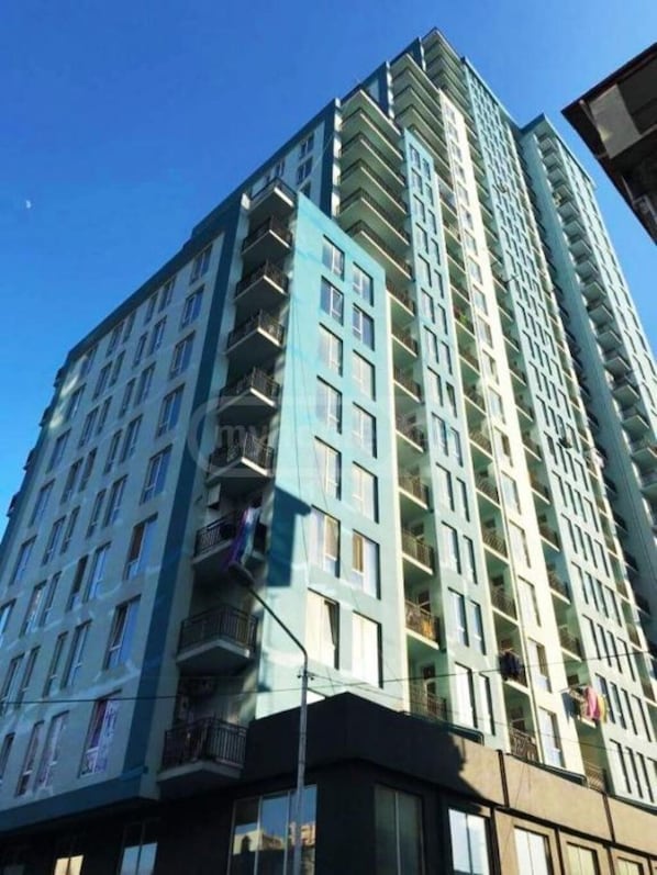 Un immeuble résidentiel de grande hauteur doté de nombreux balcons, de grandes fenêtres et d’une architecture moderne.