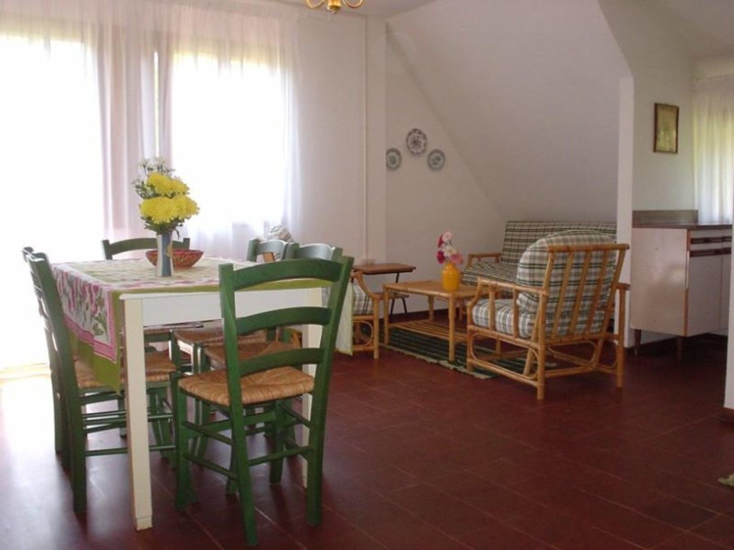 A dining area with a table, chairs, and a sofa.