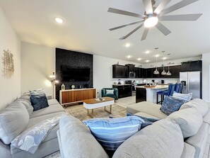 Ein modernes Wohnzimmer mit Sofa, Couchtisch und Fernseher.