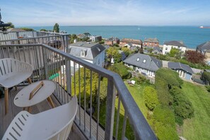 Varanda com vista para uma área residencial e o mar.