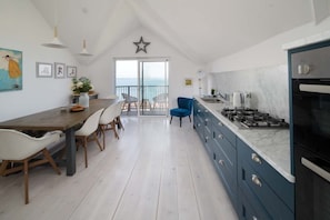 Eine moderne Küche mit einer großen Kochinsel, weißen Wänden und einem Balkon mit Sterndekoration.