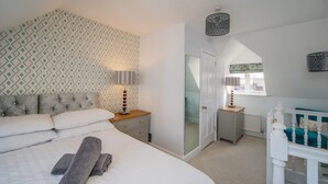 Ein Schlafzimmer mit einem Bett, Nachttischen, einem Kleiderschrank und einem Fenster.