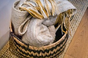 A woven basket with a fabric item inside, placed on a woven mat. - Scaw Fell Boutique Studio Annex (Cowes)