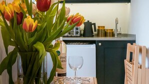A kitchen with a dining table, a bottle of wine, and a glass. - Scaw Fell Boutique Studio Annex (Cowes)