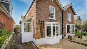 A residential brick house with a bay window, a white door, and a small garden area. - Lily Cottage Charming Gurnard Retreat by the Sea (Cowes)