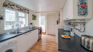 Een moderne keuken met een inbouw wasmachine, een gootsteen en een broodrooster.