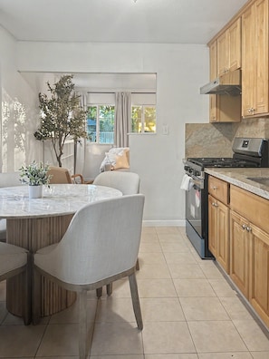 A modern kitchen with a central island, wooden cabinets, and a built-in oven. - Central Fremont. Convenient to all shops and downtown. Delux comfy. (Fremont)