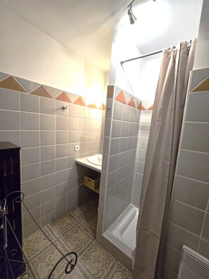 Ein Badezimmer mit Dusche, Waschbecken und Toilette.