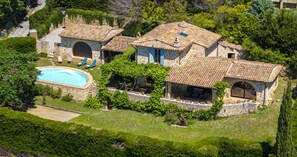 A stone villa with a swimming pool, outdoor seating, and lush greenery. - Villa Le Pré Neuf – Pool & Panoramic Views (Tourrettes-sur-Loup)