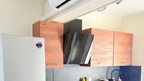 Eine Küche mit Kühlschrank, Backofen, Herd und integriertem Mikrowellenherd.
