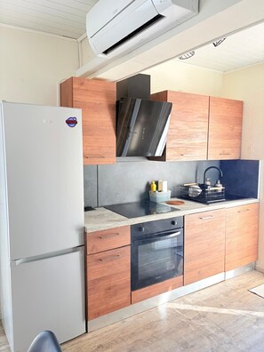 Eine Küche mit Kühlschrank, Backofen, Herd und integriertem Mikrowellenherd.