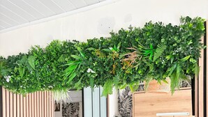 Ein moderner Wohnraum mit einer Holzwand, einer Couch, einem Couchtisch und einem Wandregal.