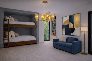 A modern bedroom with a bunk bed, a blue sofa, a floor lamp, and a bookshelf. - Ski in/ski out whole house rental-Powder Mountain, views, hot tub, sauna & more! (Eden)