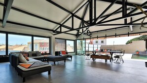 Un'ampia zona giorno con soffitto alto, ampie finestre e vista sulla città.