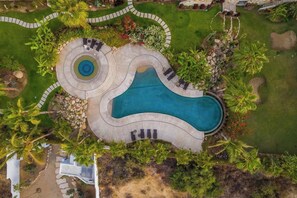 An aerial view of a landscaped area with a swimming pool, surrounded by palm trees and a walking path. - 3BR Ocean and City View - Pool - Tennis (San José del Cabo)