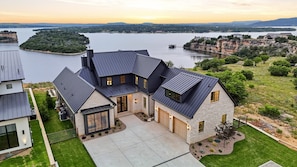 A modern house with a stone facade, a garage, and a driveway.