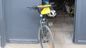 Una bicicletta parcheggiata davanti a un portone di garage.