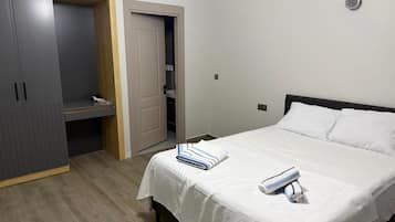 Una habitación de hotel con una cama, un armario y una puerta que da a un baño.