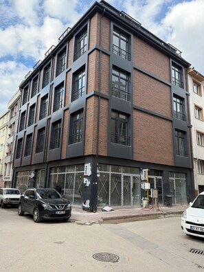 A multi-story building with a brick facade, large windows, and a visible storefront.