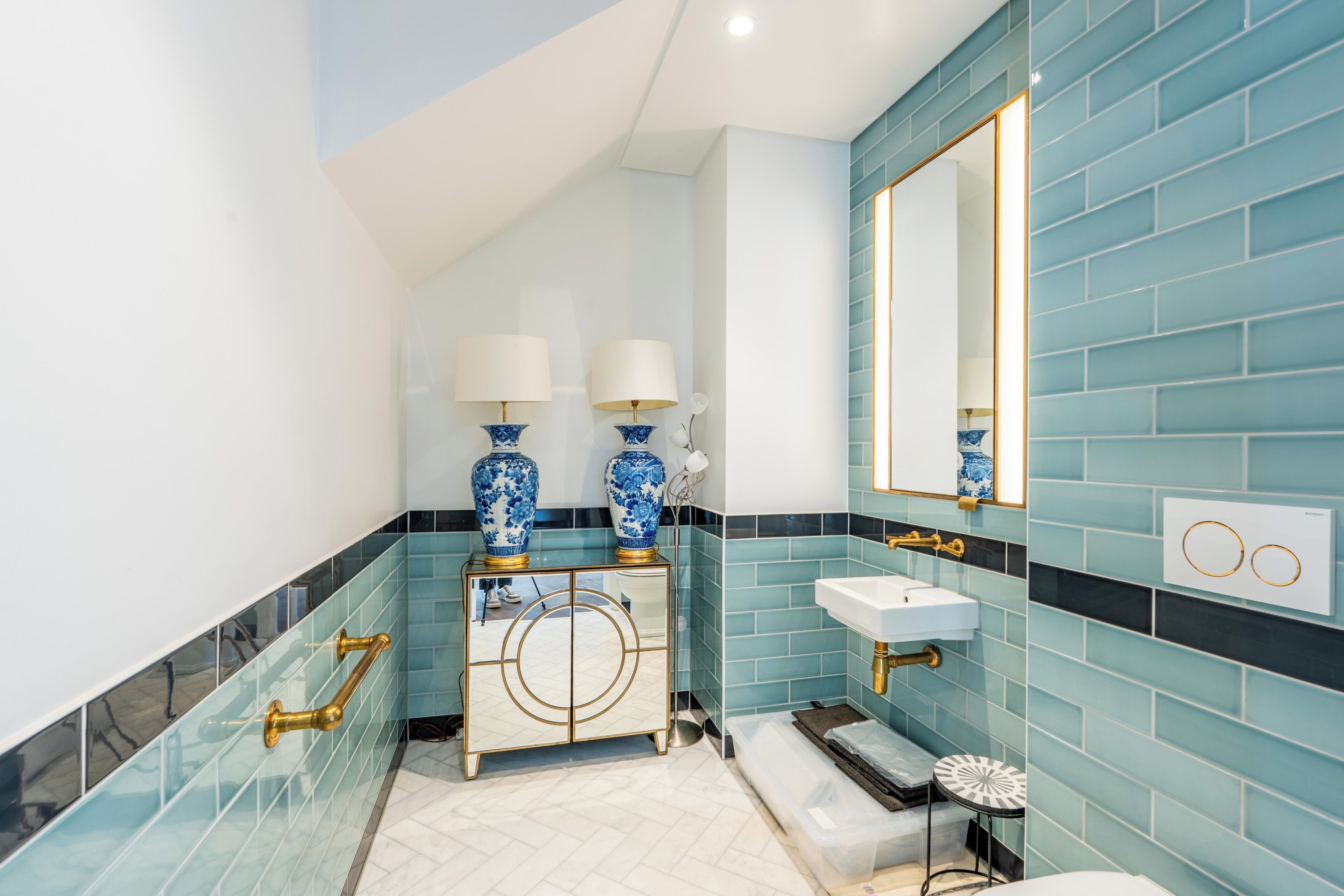 A bathroom with a vanity, sink, mirror, and decorative vases.
