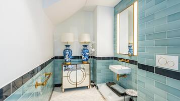 A bathroom with a vanity, sink, mirror, and decorative vases.