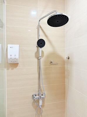 Ducha con cabezal de ducha de mano y panel de control en la pared.