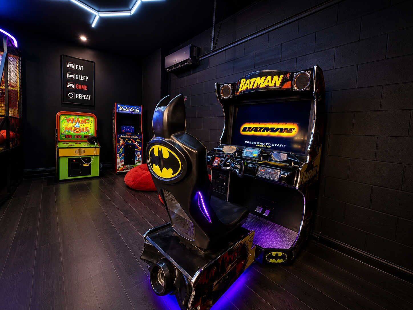 A gaming arcade with various machines, including a Batman-themed one.