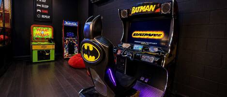 A gaming arcade with various machines, including a Batman-themed one.