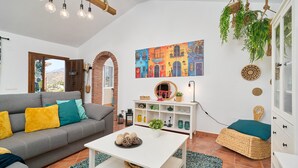 Una sala de estar con sofá, mesa de centro y estanterías decoradas.