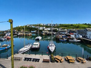 A harbor with boats docked, a wooden walkway, and buildings in the background. - Poppy's 3-bedroom house in charming Mevagissey perfect for relaxing getaway (Mevagissey)