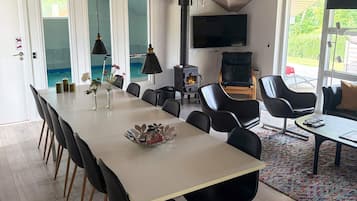 Uma sala de jantar moderna com uma mesa comprida, cadeiras pretas e uma lareira.