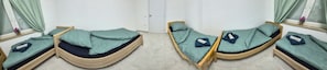 Een kamer met drie stapelbedden, elk voorzien van een kussen en een deken.