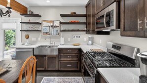Una cocina moderna con armarios de madera oscura, electrodomésticos de acero inoxidable y una isla central con un lavamanos.