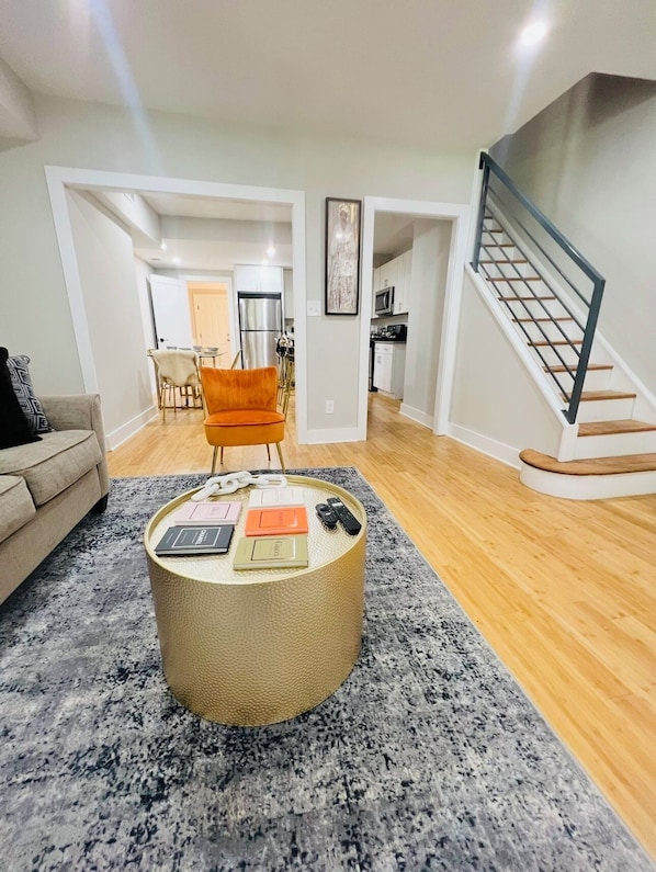 A modern living room with a round coffee table, a sofa, and a staircase. - Contemporary 4BDR House @ Popular H St Corridor (Washington)